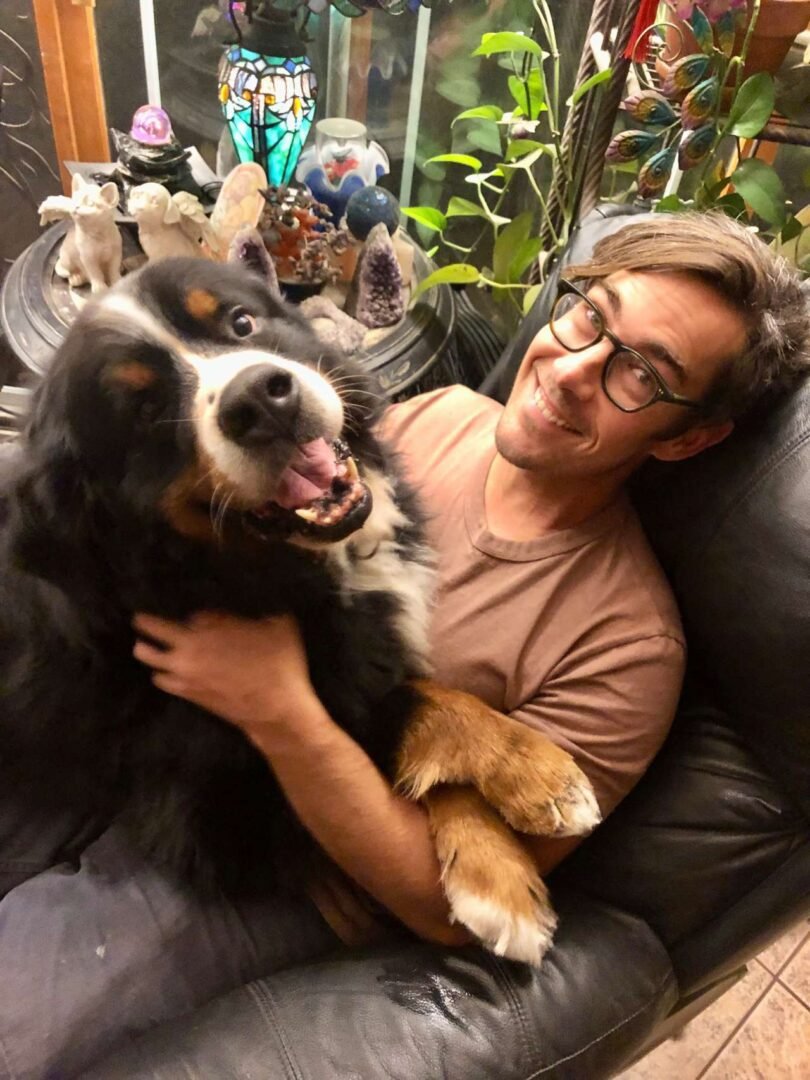 A happy owner hugging his Bernese Mountain Dog